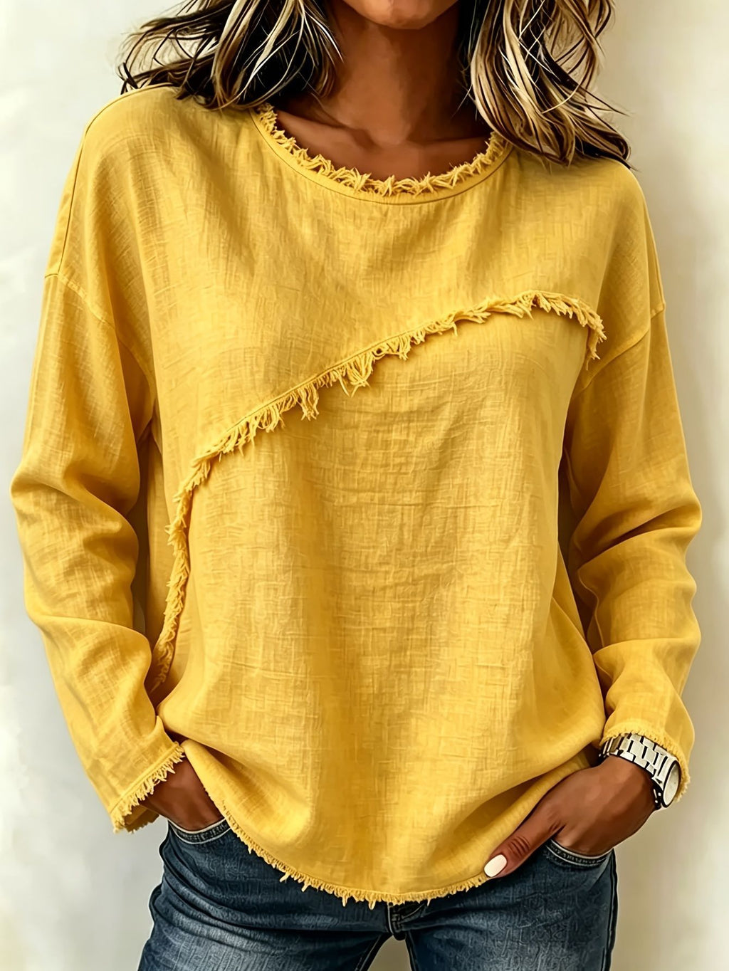 Yellow long-sleeve top with ruffled details worn by a person against a neutral background