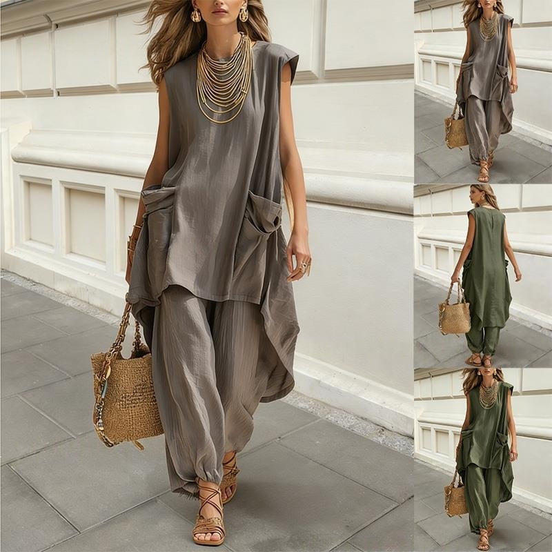 Woman wearing a gray outfit with wide-leg pants and a brown bag, standing on a stone pavement.