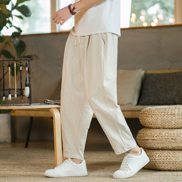 Person wearing beige pants and white sneakers in a living room setting