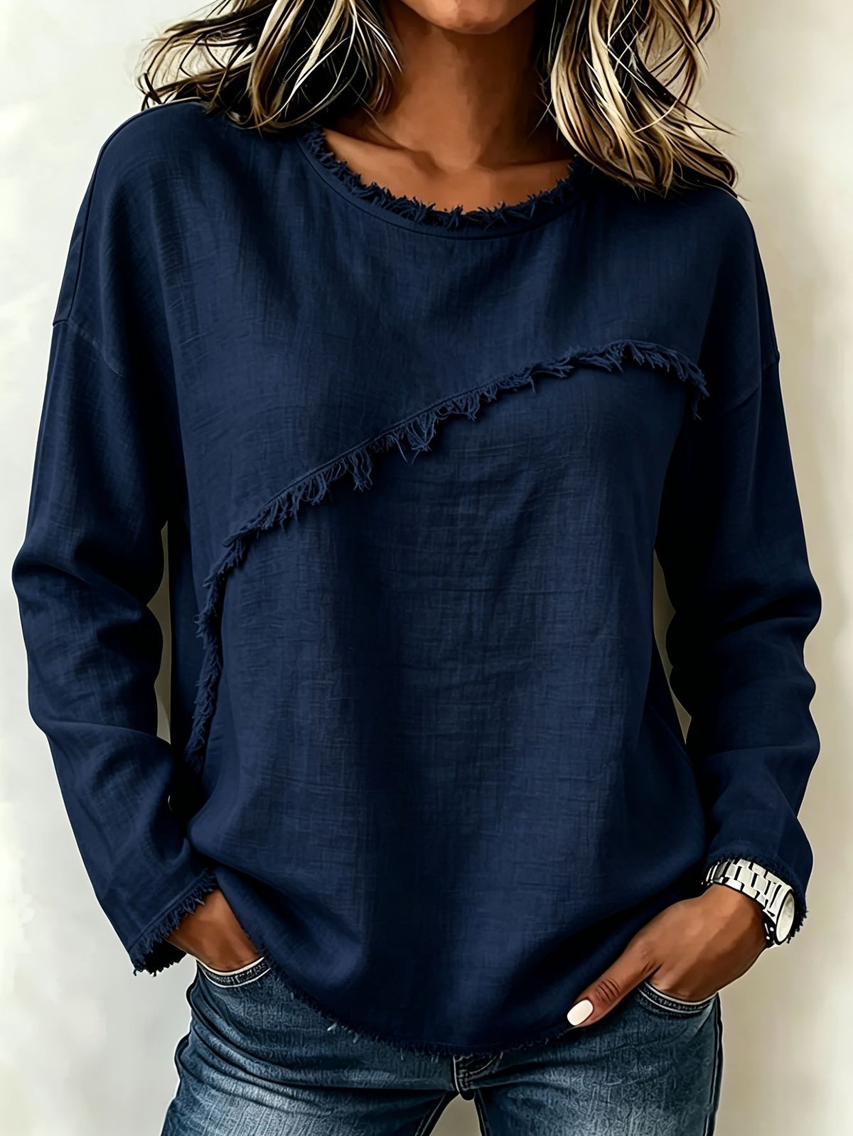 Person wearing a navy blue sweater with ruffled details on a plain background