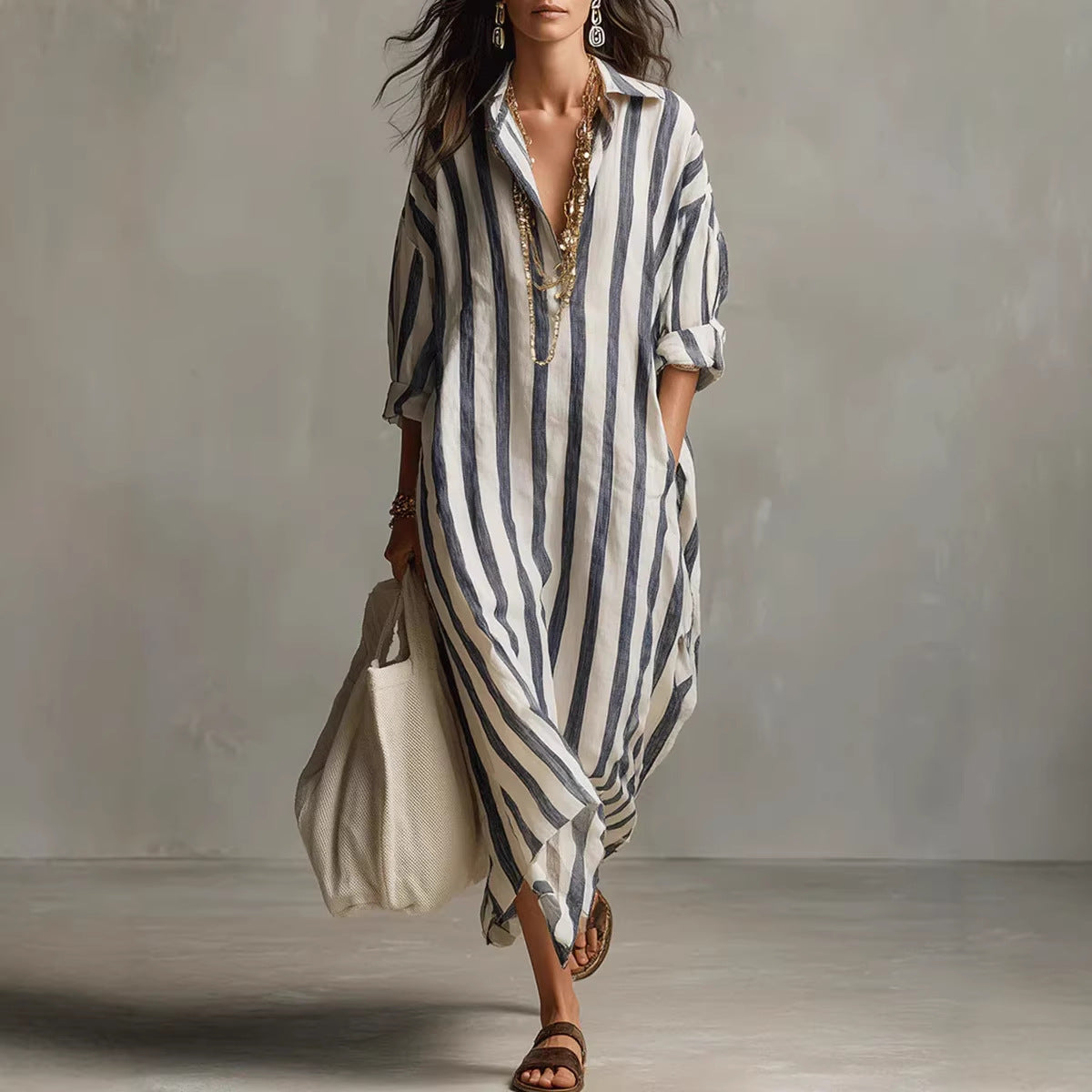 Woman wearing a long, striped dress against a neutral background
