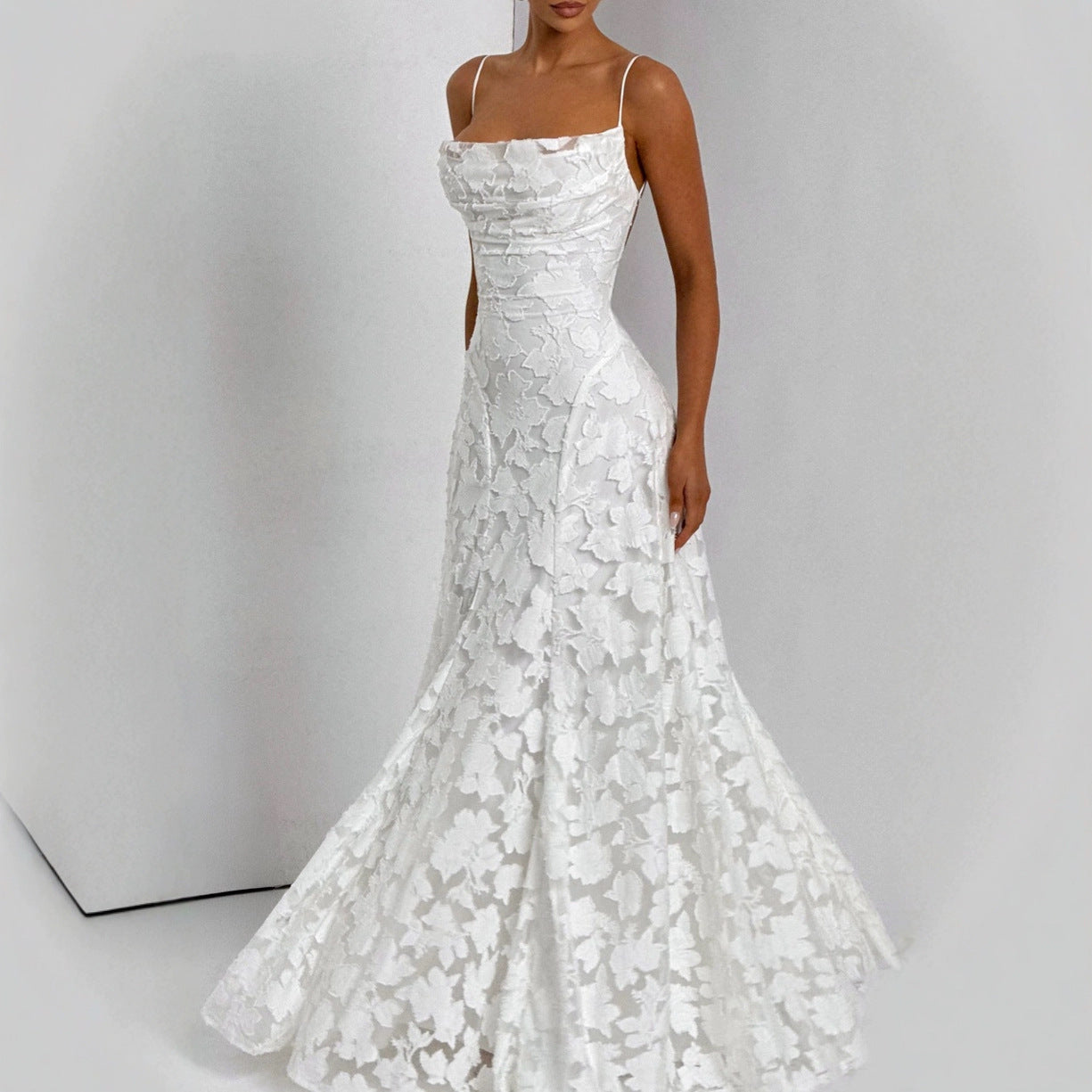 White lace wedding dress on a plain background