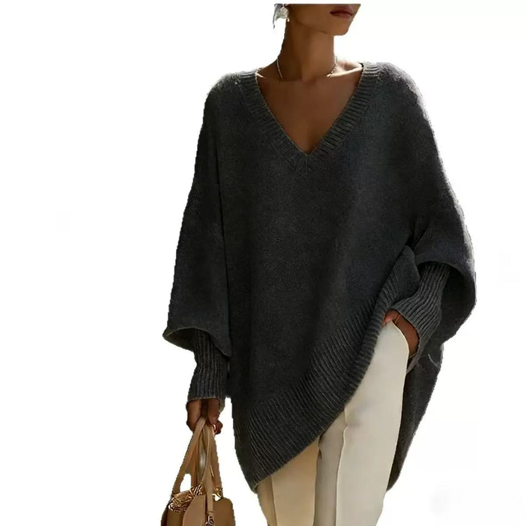 Person wearing a dark gray poncho on a white background