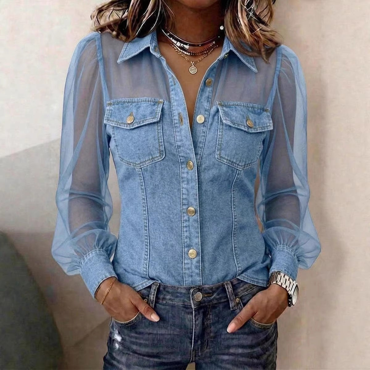 Person wearing a sheer blue denim shirt over a black top.