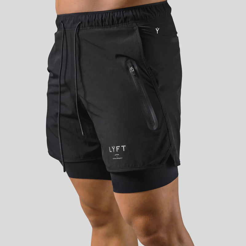 Black athletic shorts with a visible brand logo on a gray background