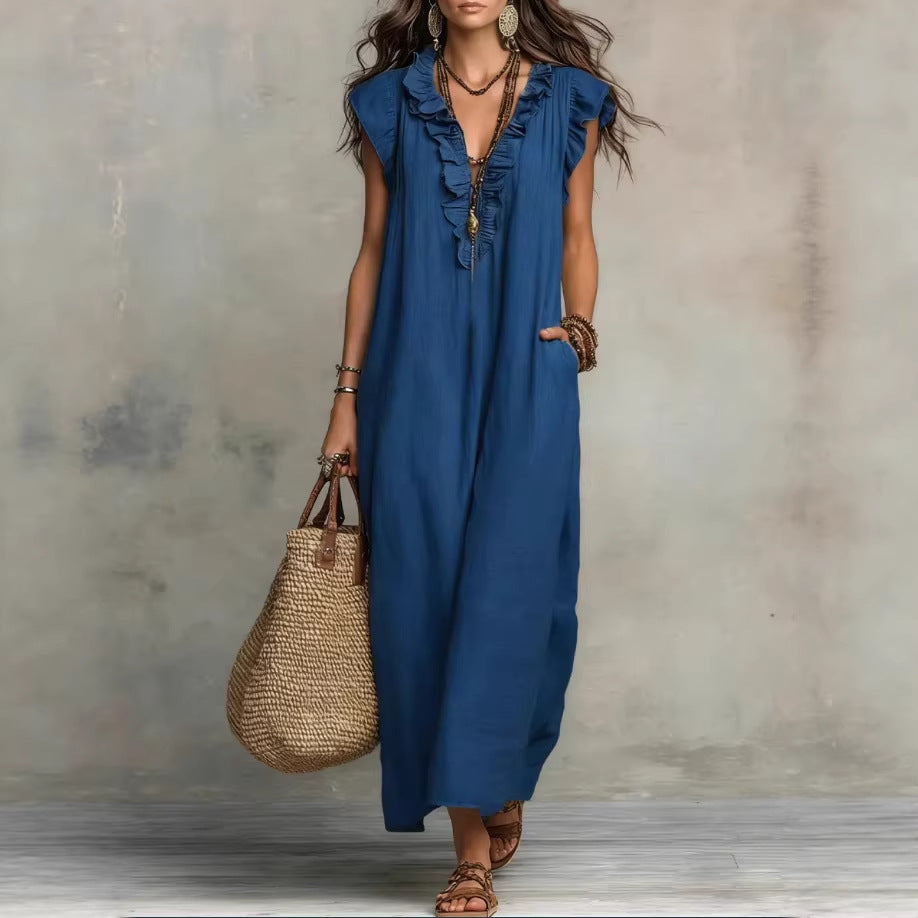 Woman wearing a blue dress holding a straw bag against a neutral background