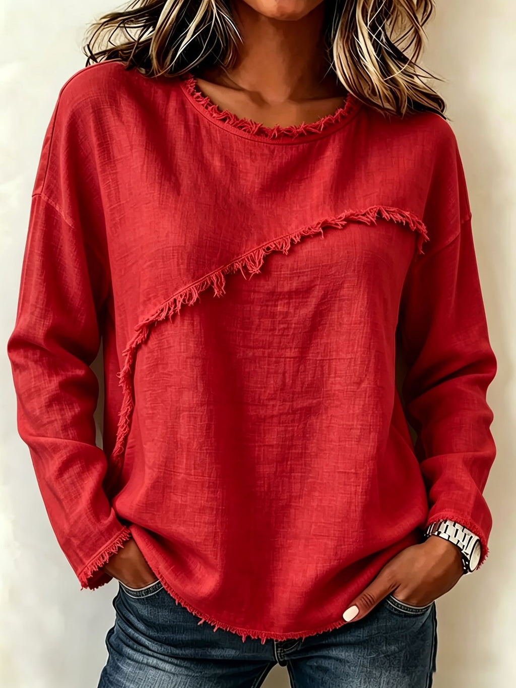 Person wearing a red frayed hem top with hands in pockets against a neutral background
