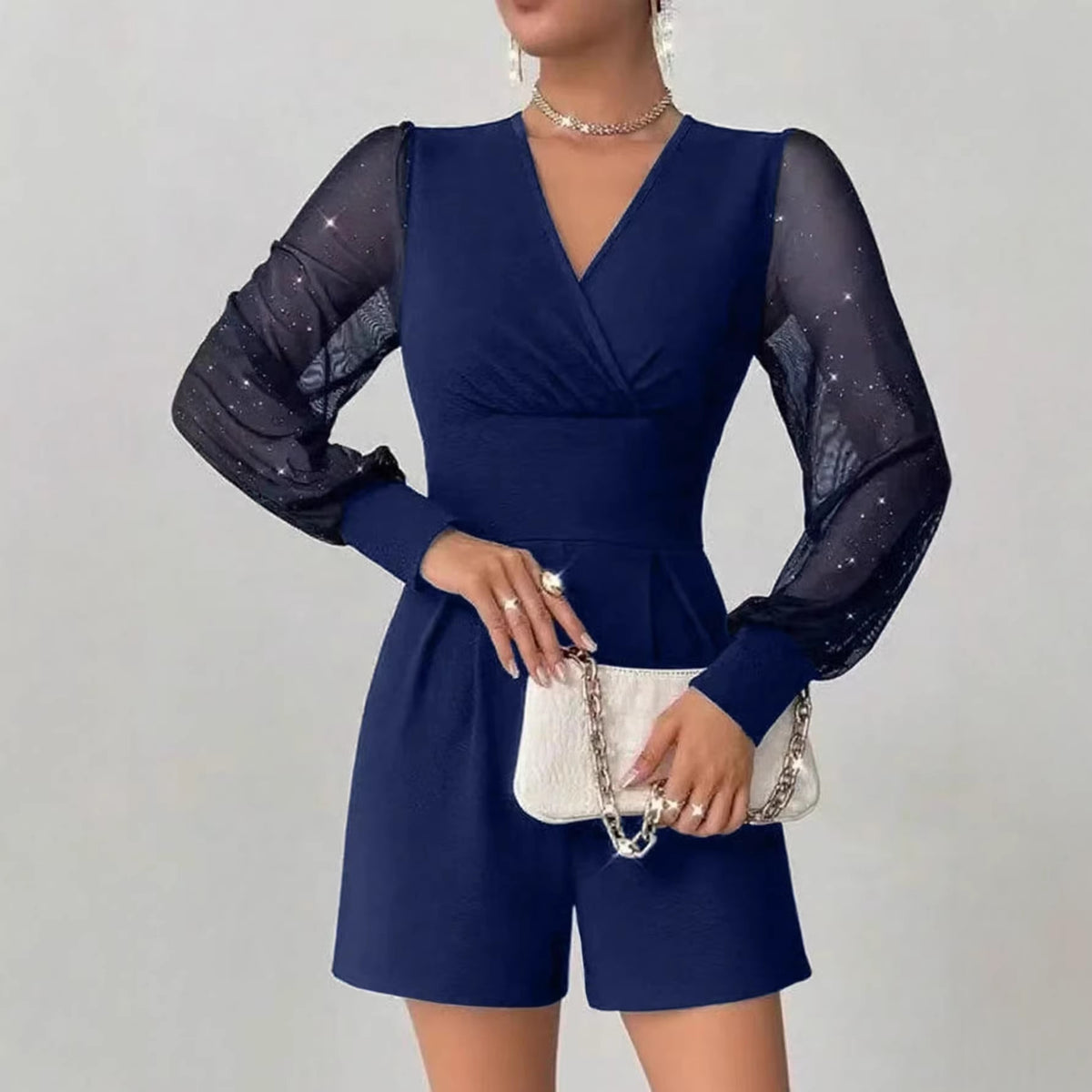Navy blue romper with sheer sleeves on a plain background
