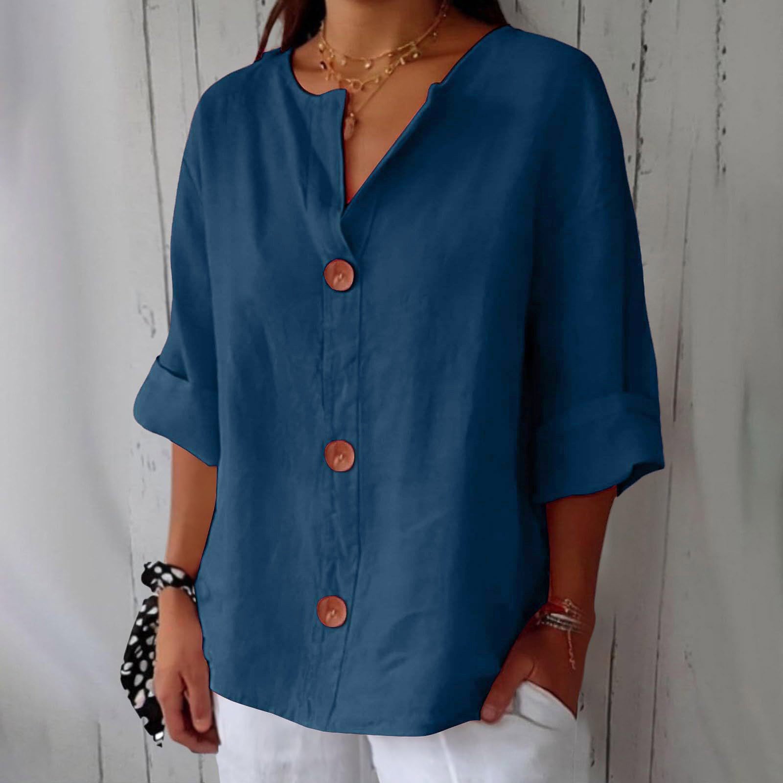 Person wearing a blue button-up shirt with a neutral background