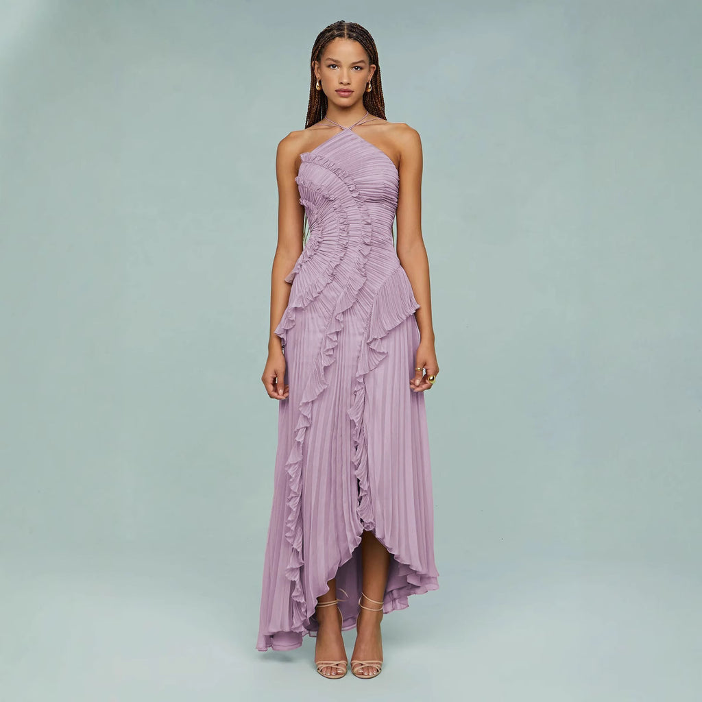 Woman wearing a purple one-shoulder dress with ruffled layers on a light gray background