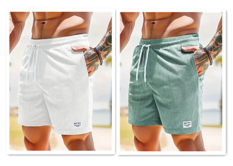 Two pairs of shorts, one white and one green, worn by a person on a blurred background.