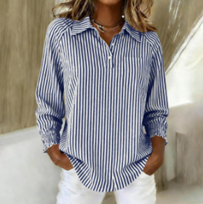 Woman wearing a blue and white striped shirt with a blurred background