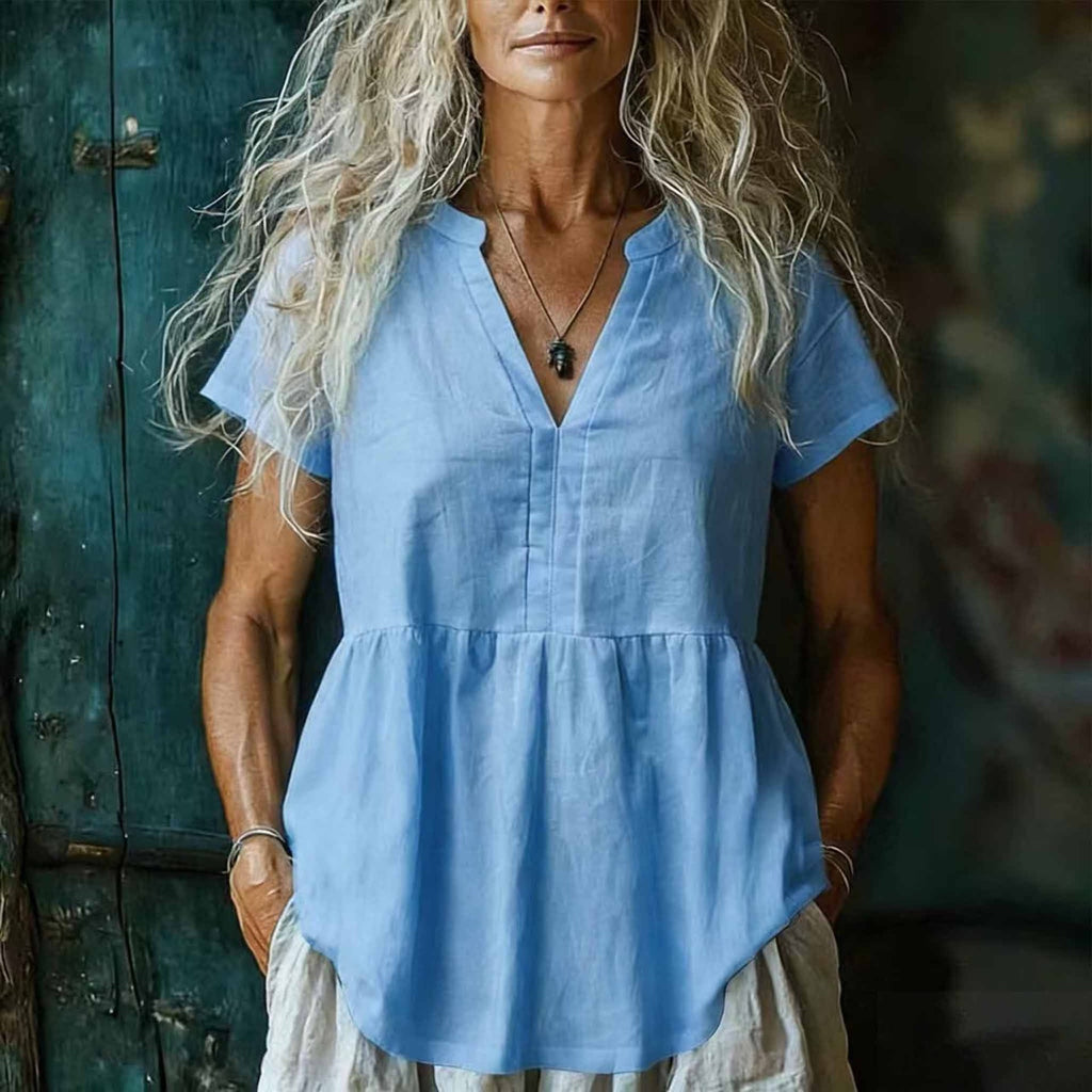 Woman wearing a light blue blouse with a blurred background