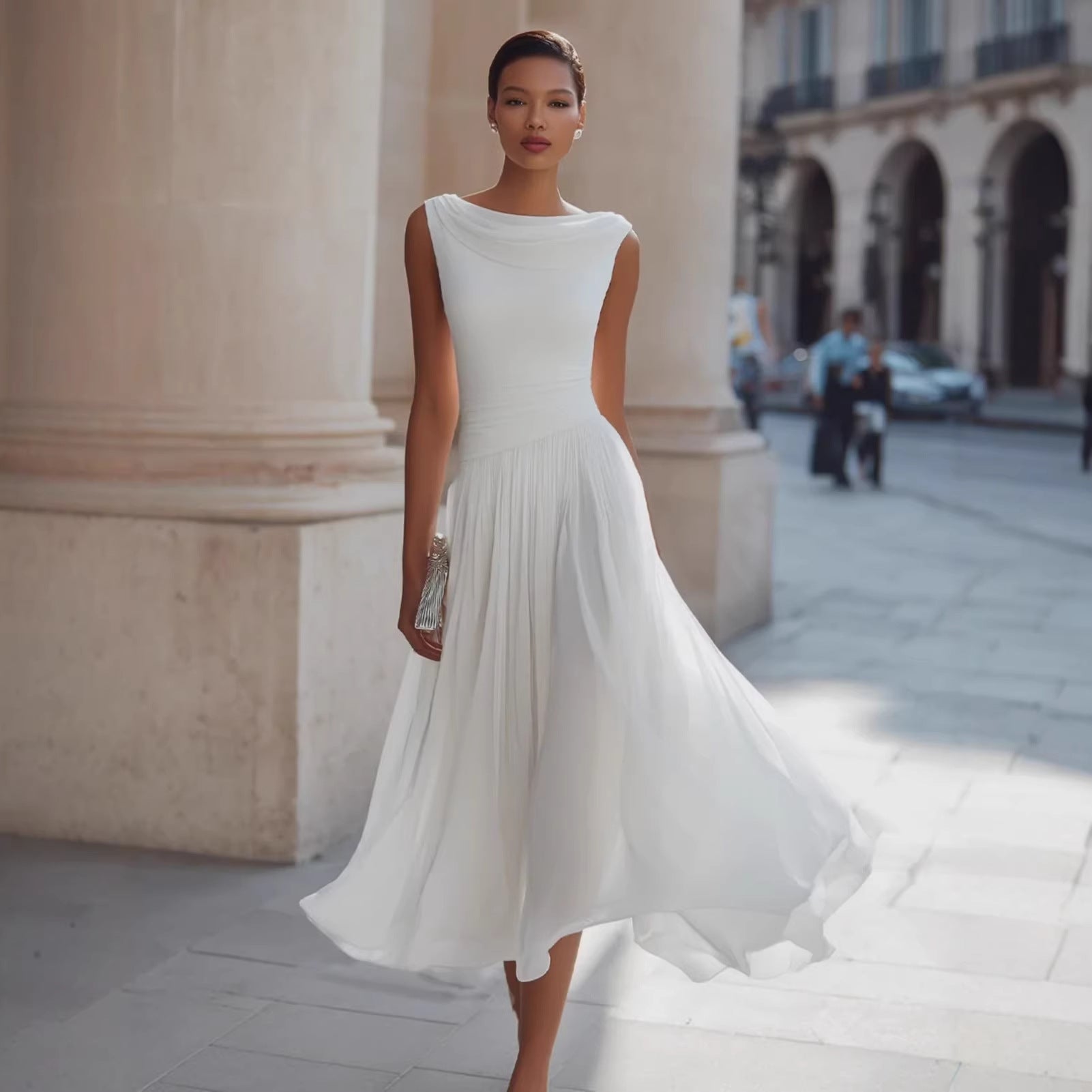 Woman in a white dress standing in an urban setting with classical architecture.