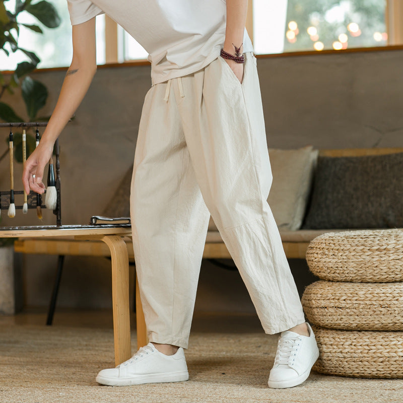 Person wearing beige pants and white sneakers in a living room setting