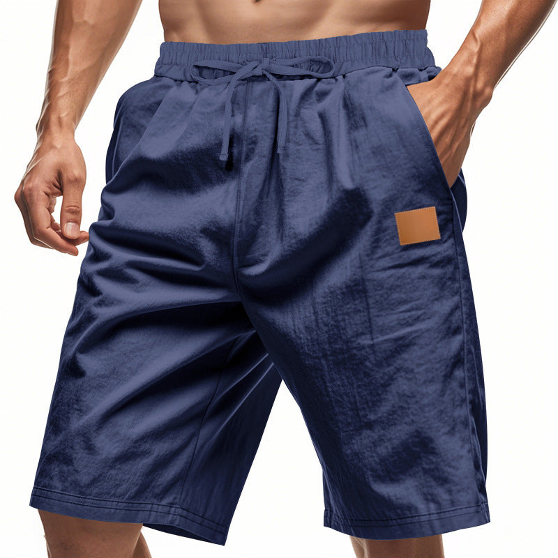 Navy blue shorts with a brown patch on a white background