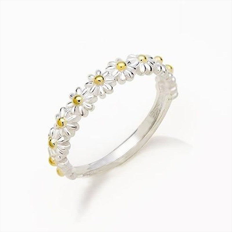 Silver ring with gold accents on a white background