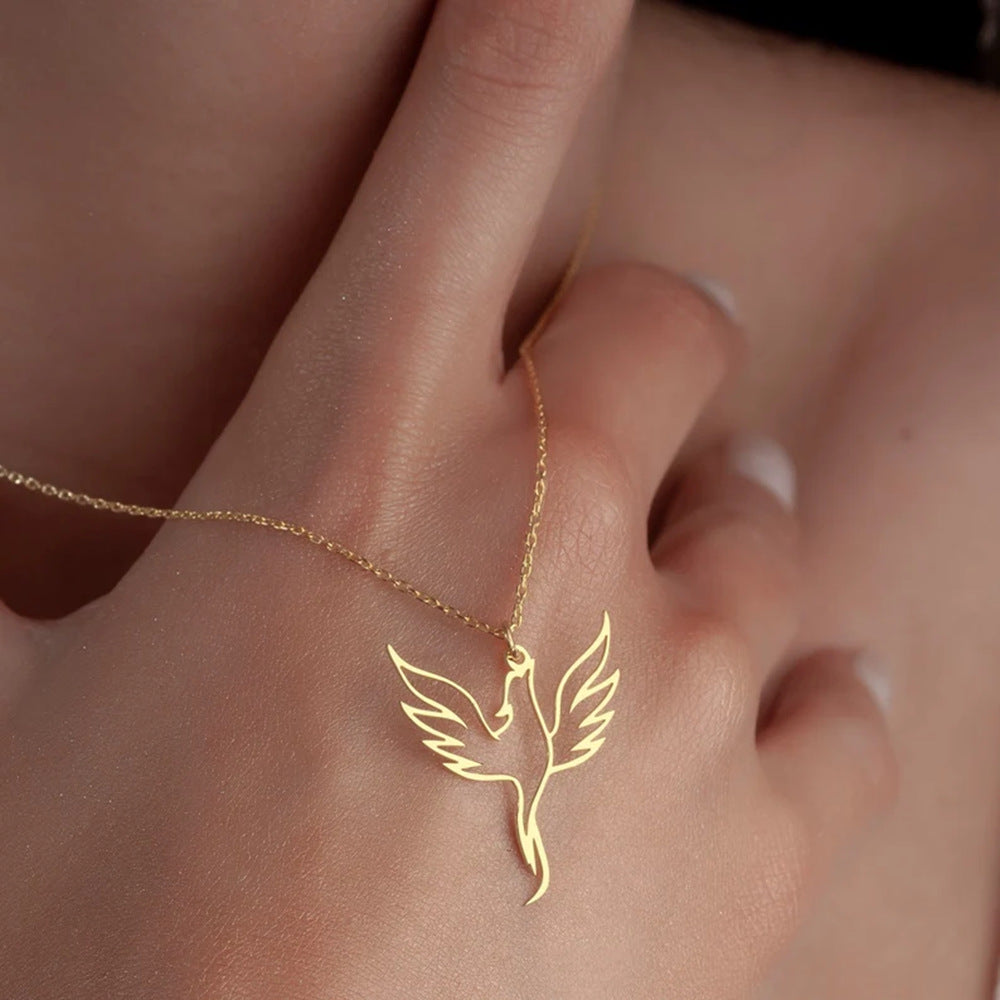 Gold necklace with a bird pendant on a hand