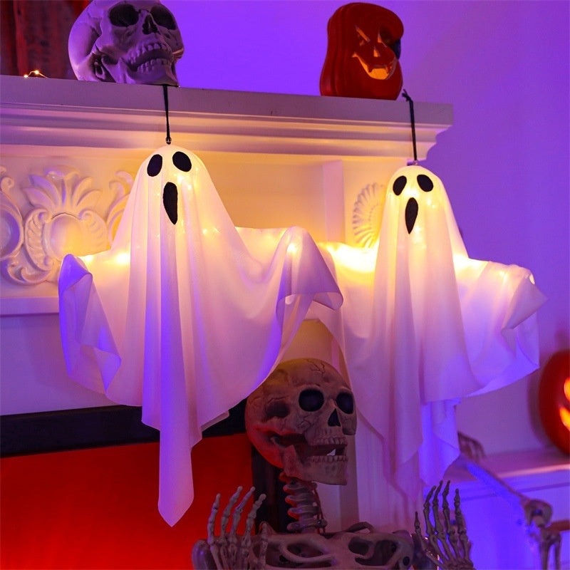 Halloween-themed decorations with ghost lights, skulls, and skeleton on a purple background.