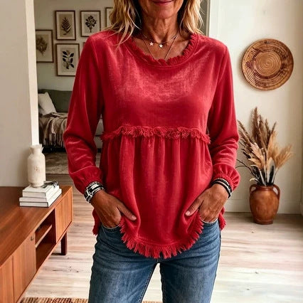 Person wearing a red top with ruffled details in a home setting