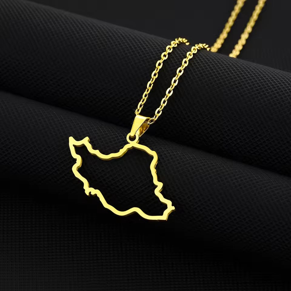 Gold necklace with a map-shaped pendant on a black fabric background