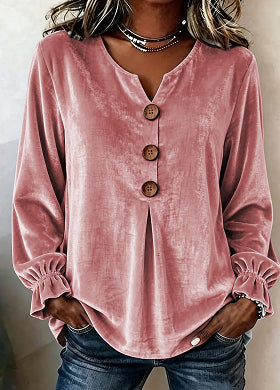 Pink long-sleeve top with wooden buttons worn by a person, against a neutral background