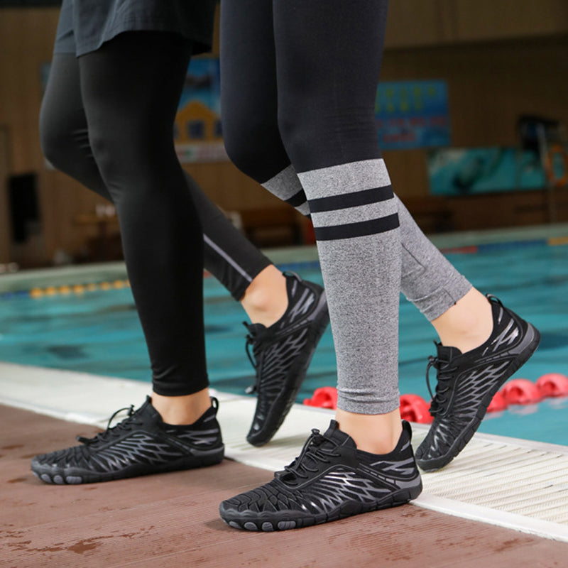 Two people wearing black athletic shoes by a pool.