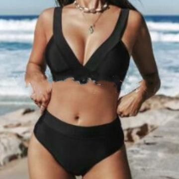 Person wearing a black bikini set on a beach with ocean in the background