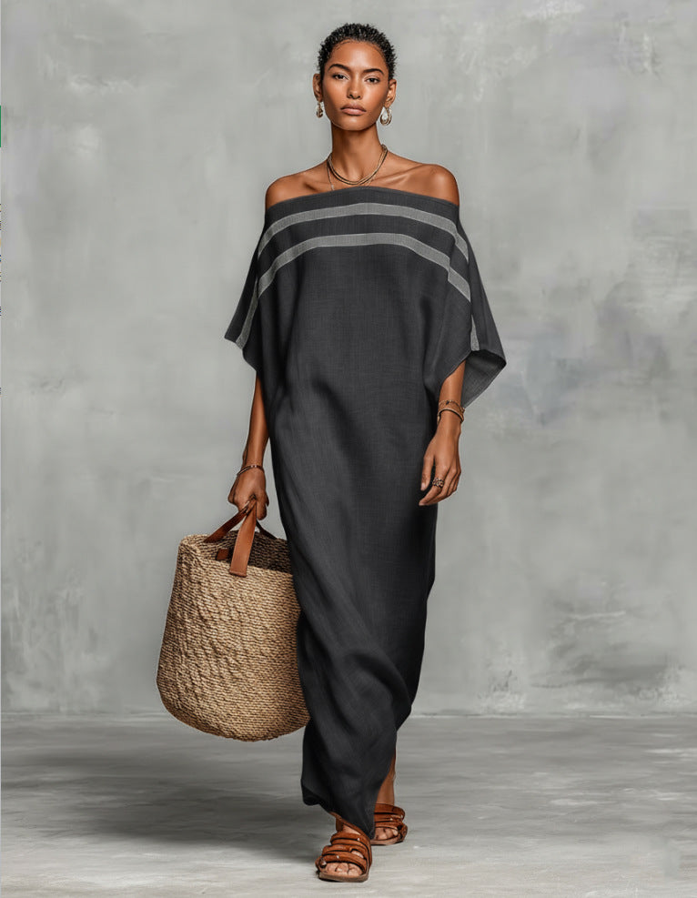 Woman wearing a dark gray off-shoulder dress holding a woven bag against a gray background