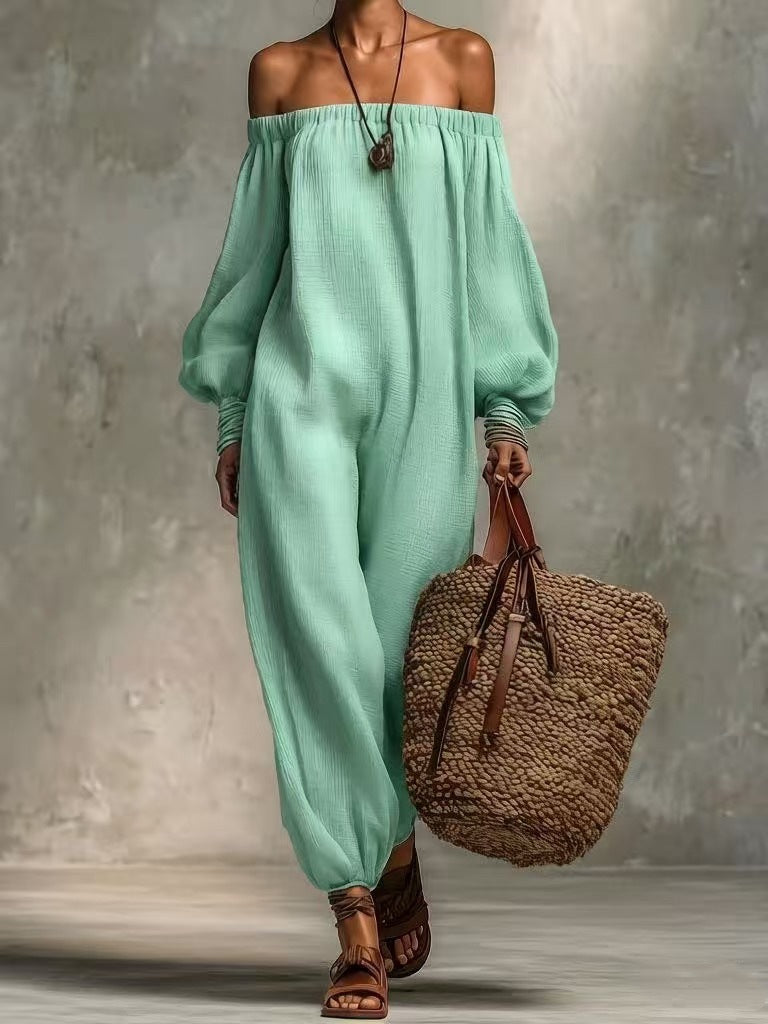 Person wearing a light green off-shoulder outfit holding a woven bag against a neutral background