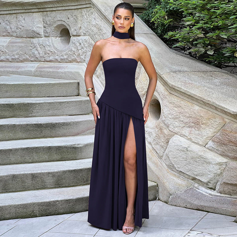 Woman in a strapless navy gown standing on stone steps with greenery in the background