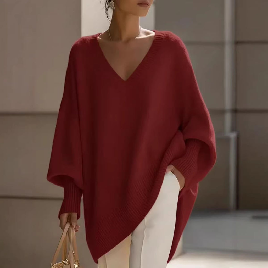 Person wearing a red sweater and white pants in an indoor setting