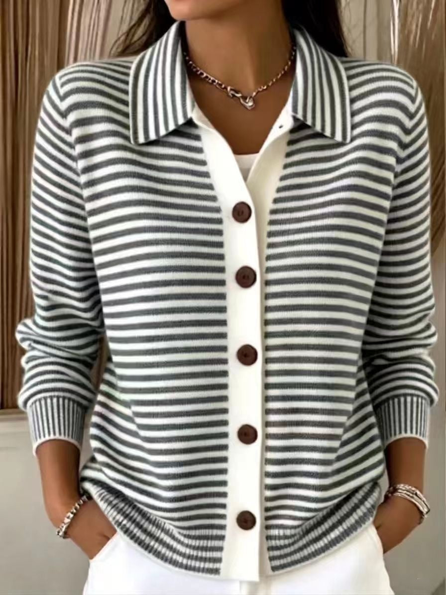 A woman wearing a gray and white horizontally striped knit cardigan with a white front placket and dark brown buttons, layered over a white top.
