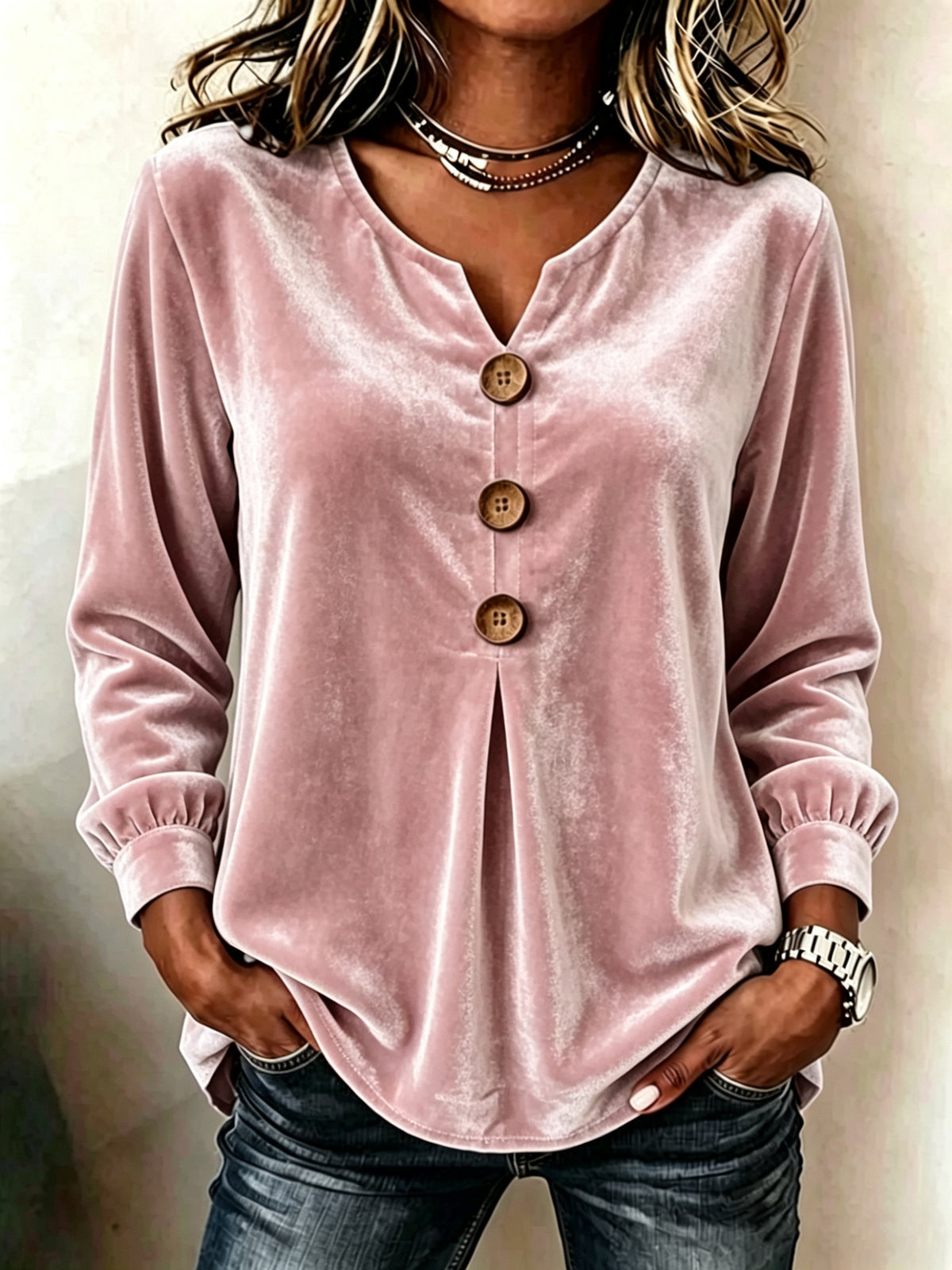Pink velvet long-sleeve top with buttons worn by a person against a neutral background