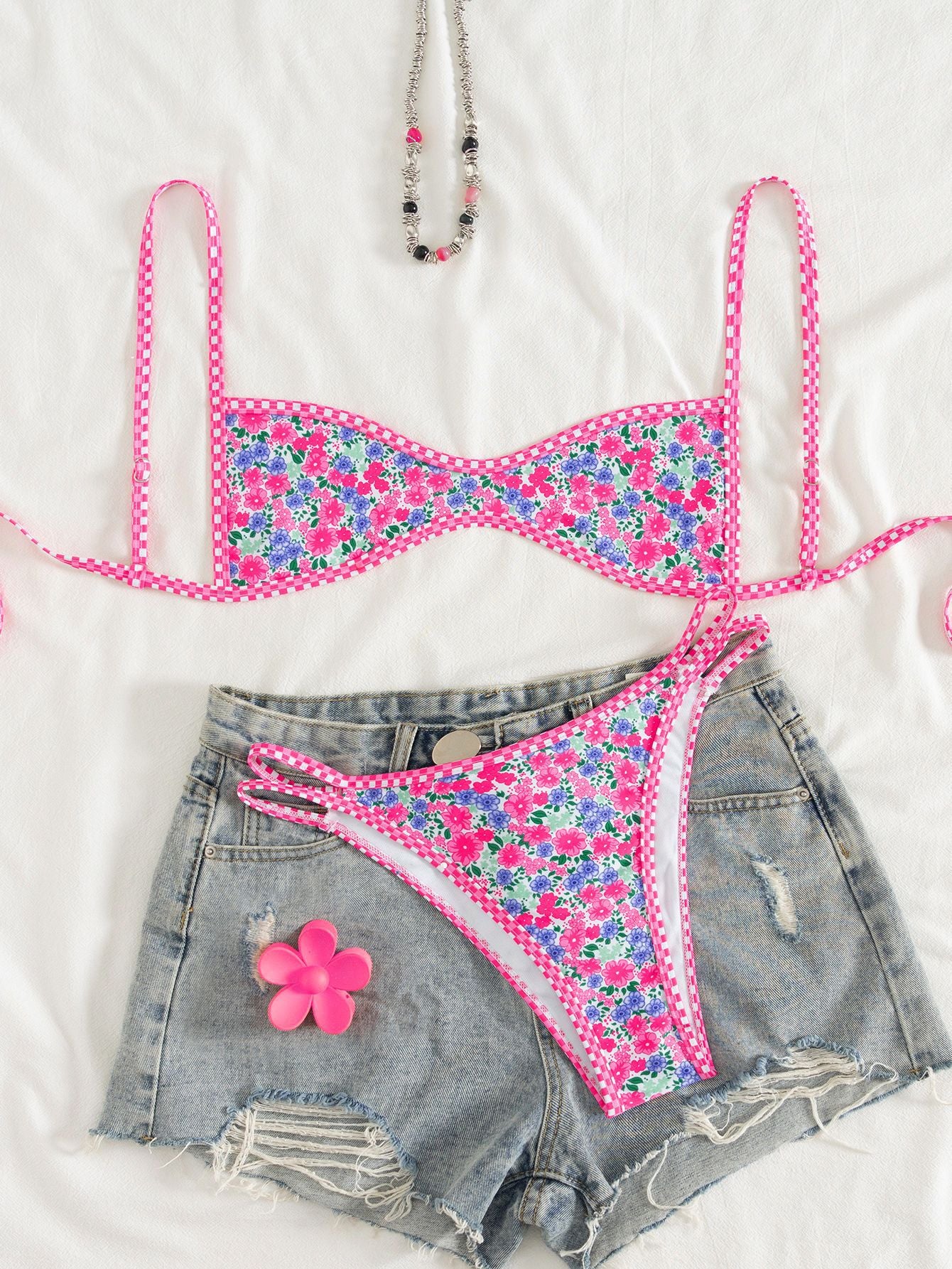Floral bikini set with denim shorts on a white background