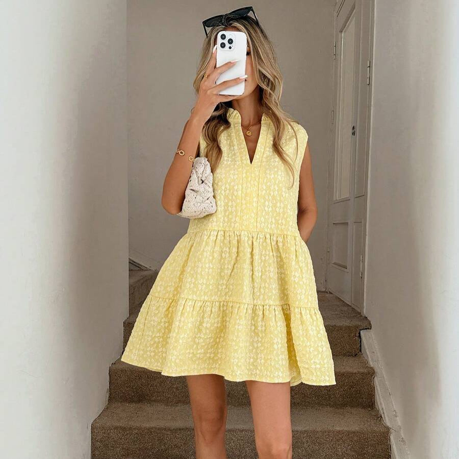 Woman taking a mirror selfie wearing a yellow dress on a staircase.