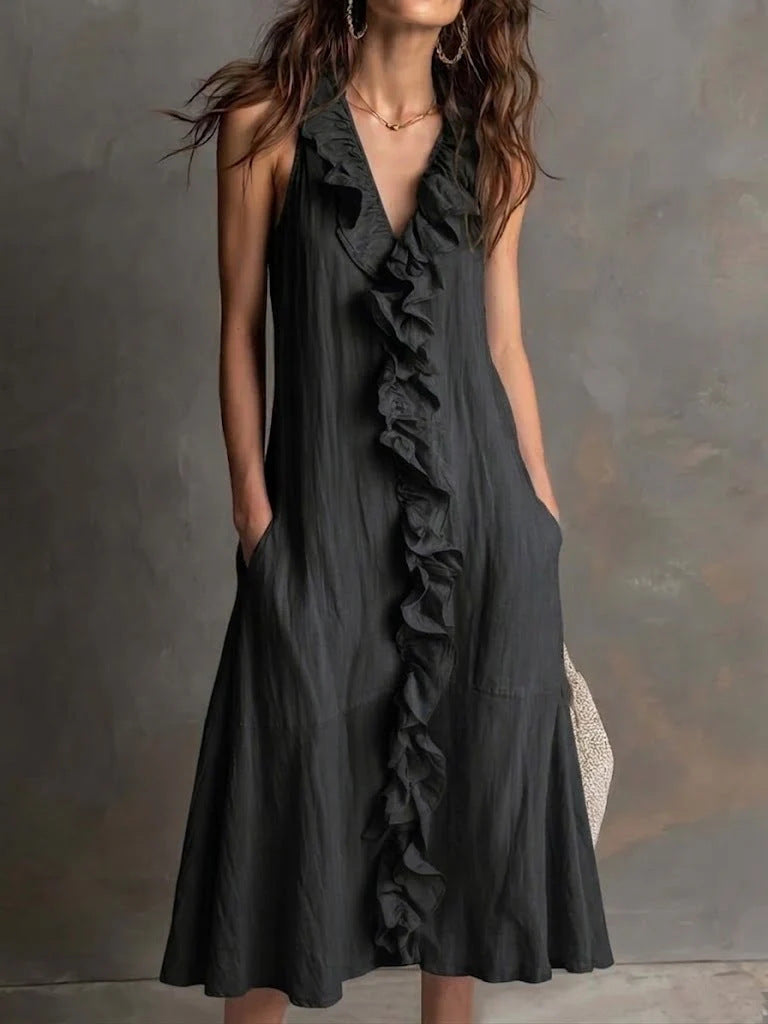 Black ruffled dress worn by a person against a gray background