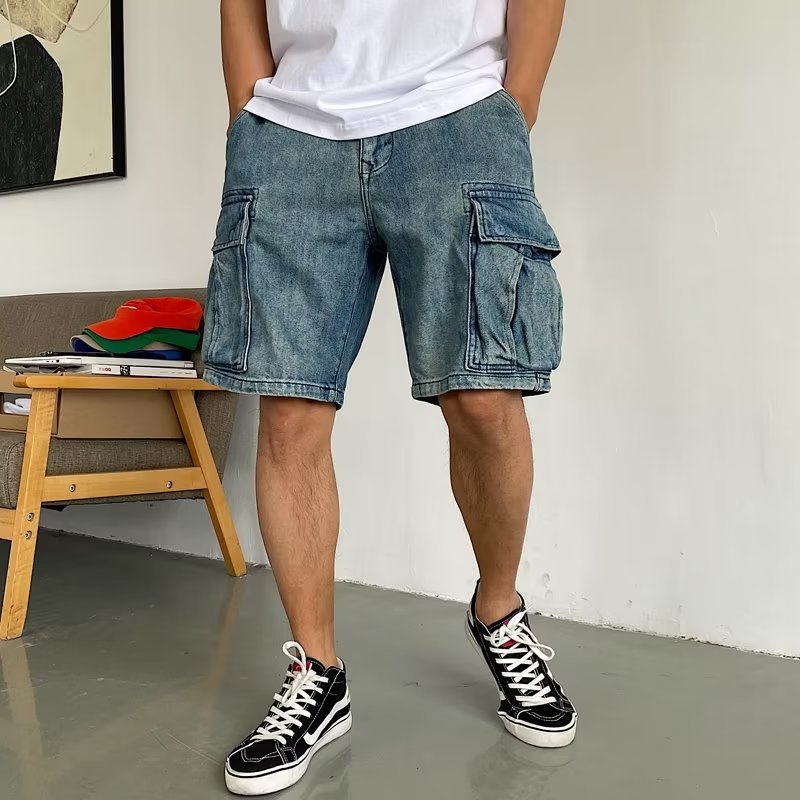 Person wearing blue denim cargo shorts and black sneakers indoors.