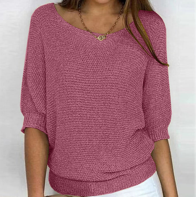 Person wearing a pink knitted sweater against a white background