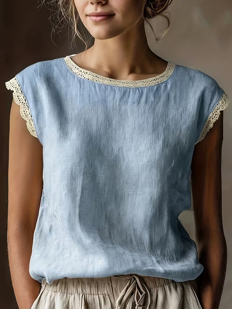Light blue top with lace trim worn by a person against a neutral background