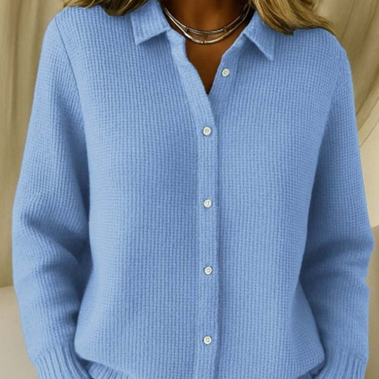 Blue textured shirt worn by a person, with a neutral background