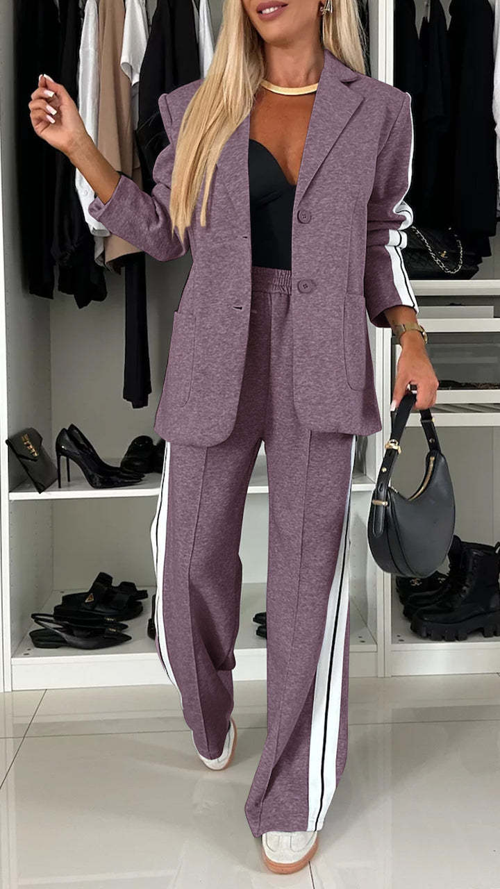 Woman in a purple suit with white stripes standing in a room with shelves of shoes and clothing.