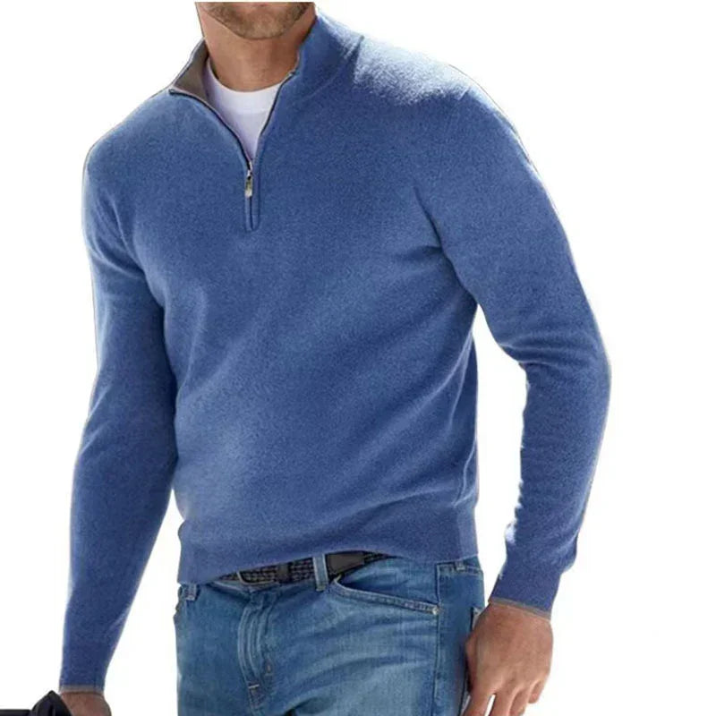 Man wearing a blue quarter-zip sweater and jeans on a white background