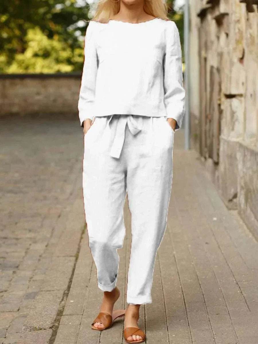 Woman wearing a white long-sleeve linen set with tie waist pants, walking outdoors, ZA-Zola fashion
