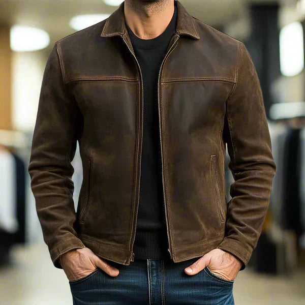Brown leather jacket worn by a person with a blurred indoor background