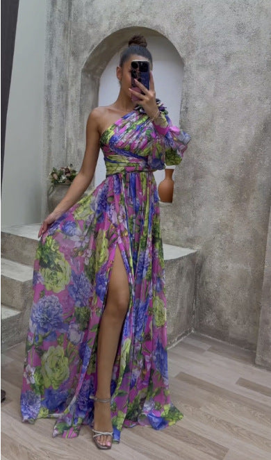 Woman in a colorful floral dress taking a mirror selfie in an indoor setting.