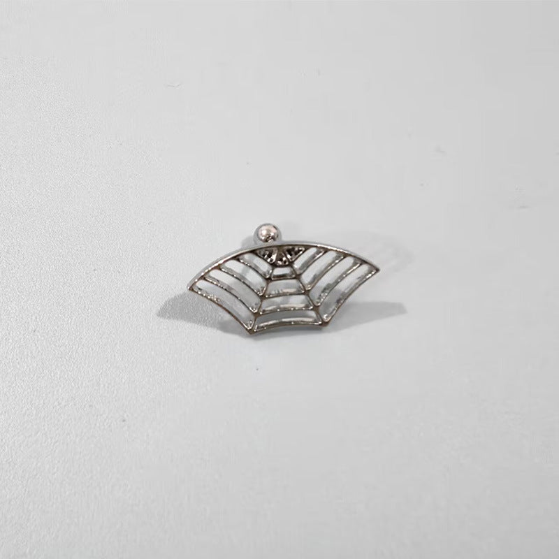 Silver spider web charm on a light gray background