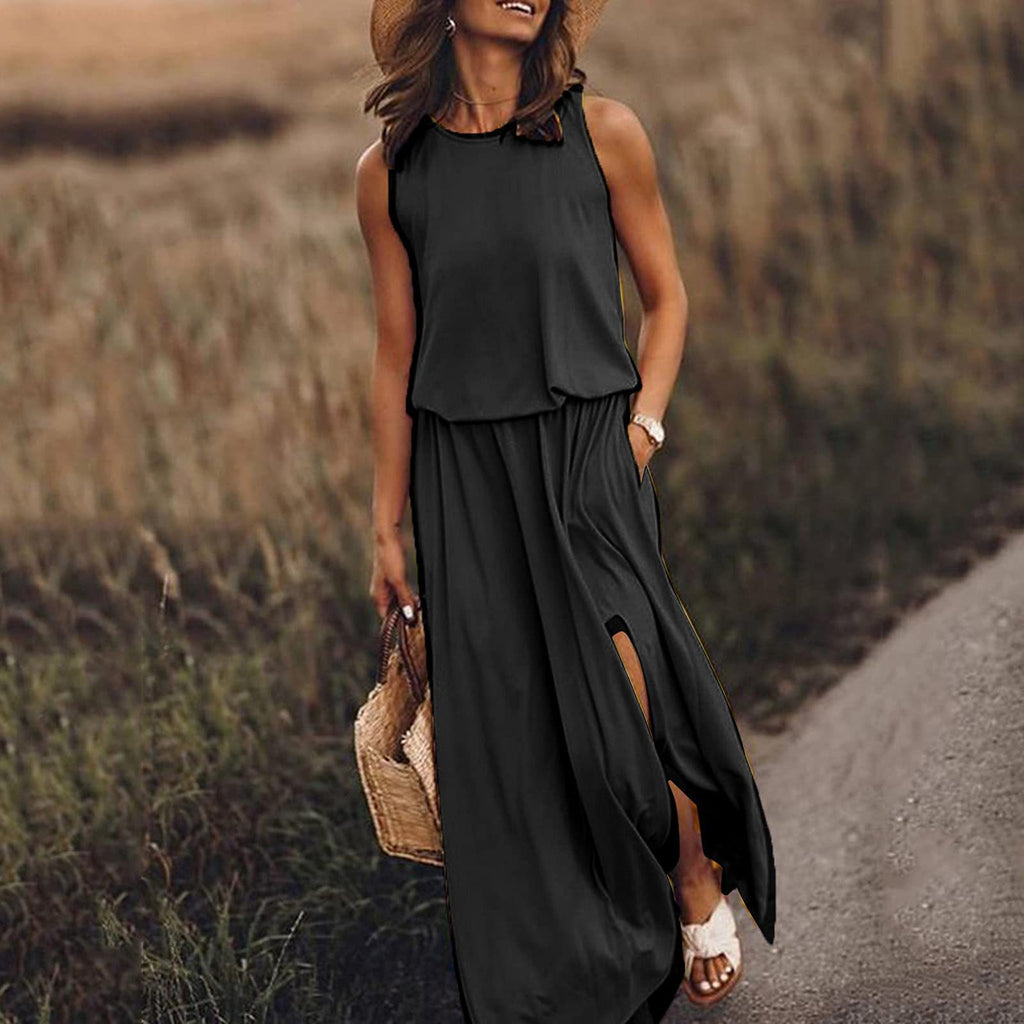 Woman in a black sleeveless dress walking on a path with a straw hat and bag.