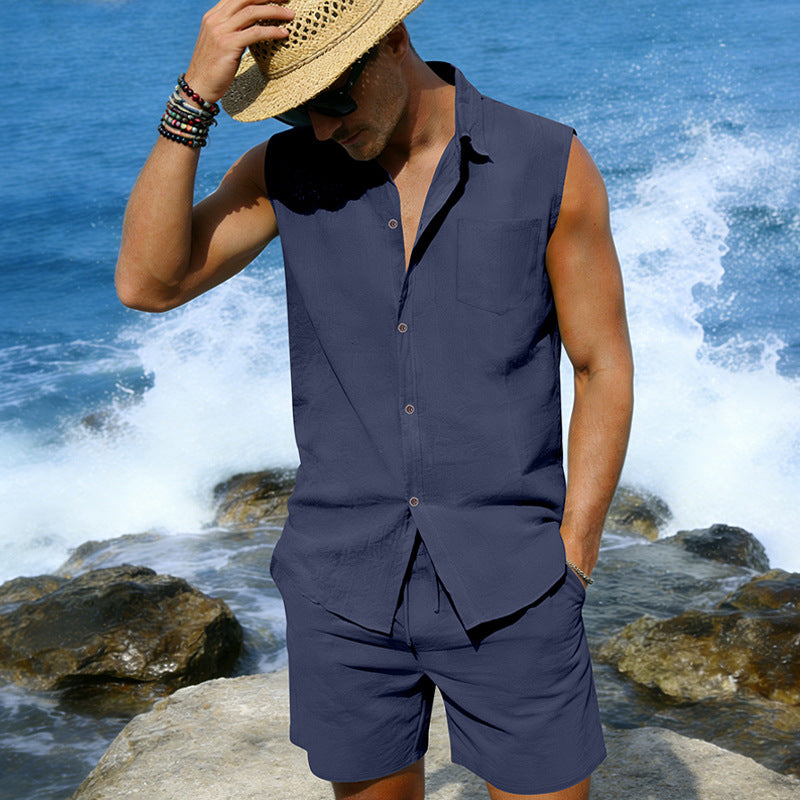 Man wearing a sleeveless navy shirt and shorts with a straw hat against a blue ocean background.