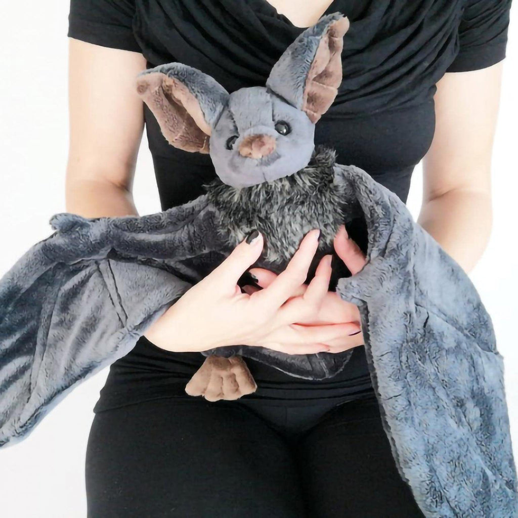 Person holding a plush bat toy against a white background